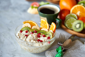 Breakfast still life with oatmeal porridge, fruits and coffee cup, top view, selective focus, shallow depth of field.