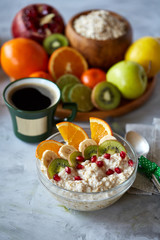 Breakfast still life with oatmeal porridge, fruits and coffee cup, top view, selective focus, shallow depth of field.