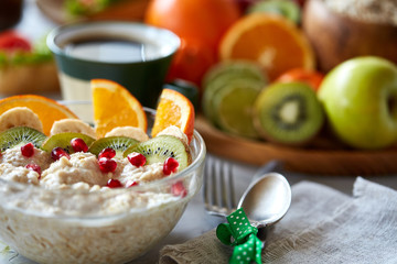 Breakfast still life with oatmeal porridge, fruits and coffee cup, top view, selective focus, shallow depth of field.