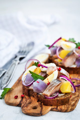 Open sandwich (smorrebrod) with herring, onion, potato and eggs