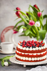 Delicious homemade red velvet cake decorated with cream and fresh berries