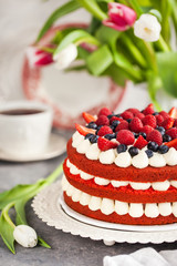 Delicious homemade red velvet cake decorated with cream and fresh berries