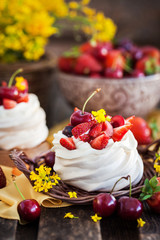 Delicious mini Pavlova meringue cake decorated with fresh berries