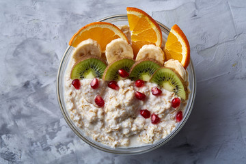 Diet breakfast oatmeal with fruits and bowl with oat flakes, selective focus, close-up