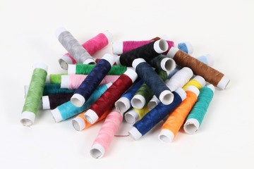 Fototapeta na wymiar different colorful sewing cotton rolls lying in the studio