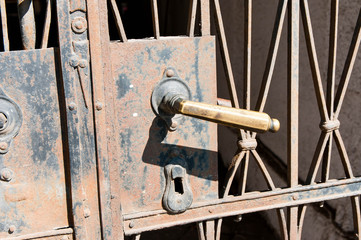 Old rusty iron door handle close up shot on bright sunny day.