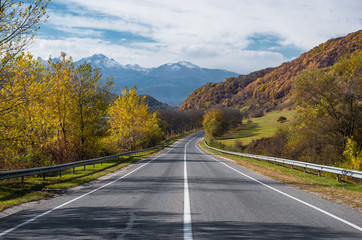 Road leads to cloud covered mountains in th autumn.