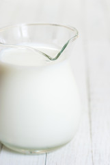 Milk jug on white wooden table