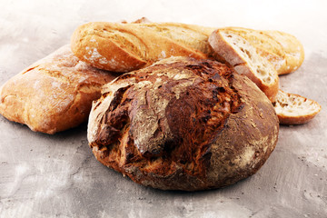 Different kinds of bread and bread rolls on board from above. Kitchen or bakery poster design
