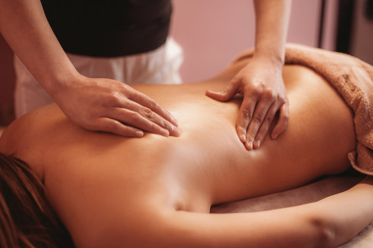 a masseur doing relax massage of back for woman