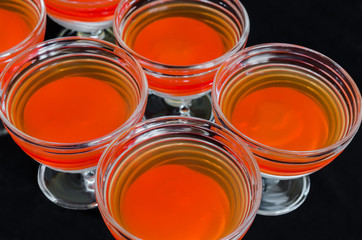 sweet delicious dessert of multi-colored jelly in a glassware isolated on a black background