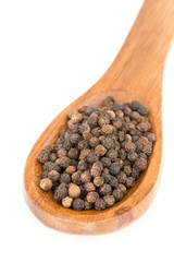 Heap of raw, natural, unprocessed black pepper peppercorns in spoon