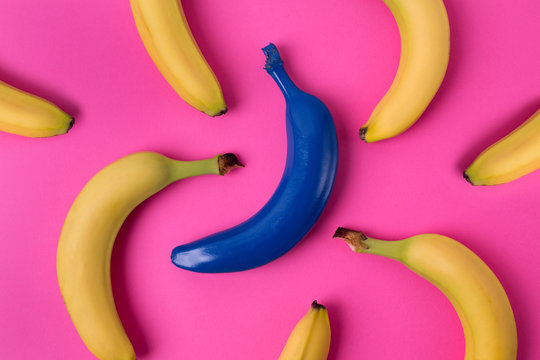 Top view of fresh yellow and blue bananas isolated on pink background.