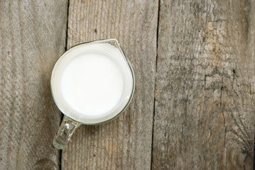 Milk jug on old wooden table