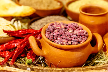 Dry red beans are in a clay pot.