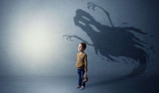 Scary ghost shadow in a dark empty room with a cute blond child