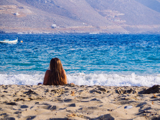 Amorgos, Greece-August 2,2017.A girl enjoying the sun and the sea on the beach of Psili Ammos.