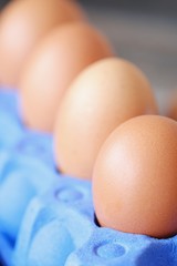 Chicken eggs in the purple package on the table 