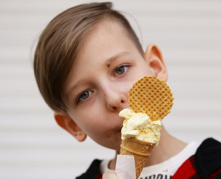 Cute young boy eating ice cream in waffle cone