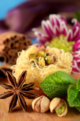 Egyptian dessert Kunafa made of kataifi dough with pistachios surrounded by spices, flowers and nuts