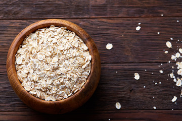 Diet breakfast oatmeal with fruits, bowl and spoon with oat flakes, selective focus, close-up