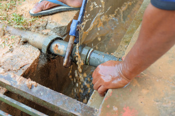 Workers repairing leaked galvanized steel pipes using pipe work hand tools
