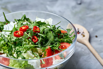Dietary mixed salad in glass sultana served with wooden spoon on white background, selective focus