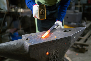 The blacksmith forges the luminous metal in the furnace, kicks out the sparks