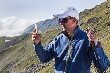 Man tourist takes pictures on mobile phone.