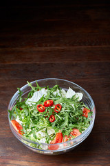 Dietary mixed salad in glass sultana on rustic wooden background, selective focus