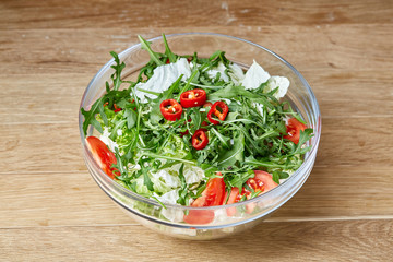 Dietary mixed salad in glass sultana on rustic wooden background, selective focus