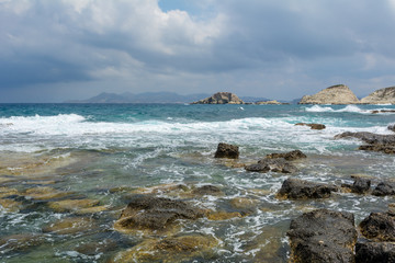 Fototapeta na wymiar Rocky coast and turquoise sea water in Mandrakia village on Milos island. Greece.