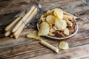 Snacks for beer on a wooden table. Chips, croutons, bread sticks