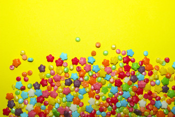 Abstract Colorful Background. Colorful Candies On Yellow Background With A Lot Of Copy Space For Text.Many Multicolored Candy Sweets On Yellow Background.Closeup Of Multicolored Small Candies.