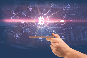 Hand using phone with cryptocurrency bitcoin link network and online concept
