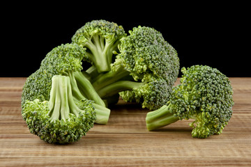 broccoli on a wooden table isolated on a black background