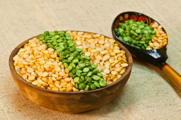 Dry split yellow and green peas in a clay bowl for pea porridge or soup 