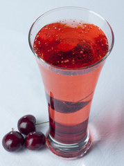 A glass of Cherry Juice close up with cherry fruit and Bubles