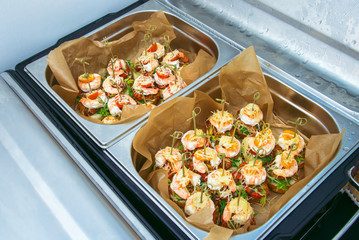 Hot Delicates, appetizer canape with tiger shrimp, fused cheese and vegetables. Catering service.