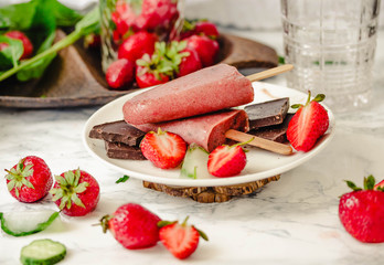 Strawberry ice cream with a banana and chocolate on a stick. Summer fresh dessert. Mint. Detox diet and summer food concept.Selective focus.