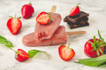 Strawberry ice cream with a banana and chocolate on a stick. Summer fresh dessert. Mint. Detox diet and summer food concept.Tone.