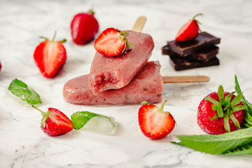Strawberry ice cream with a banana and chocolate on a stick. Summer fresh dessert. Mint. Detox diet and summer food concept.Horizontal.