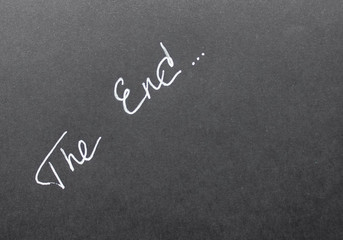 Fototapeta premium On a black background the word The End is written in white font on the diagonal
