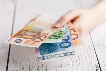 Close up female hands holding few euro banknotes