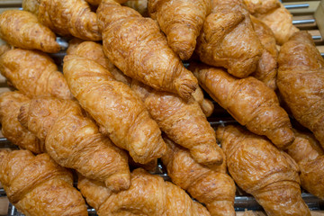 Closed up traditional croissant made with organic whole wheat flour on wooden rack