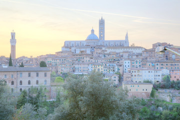 Fototapeta na wymiar Beautiful panoramic view of the medieval old town of Siena at sunrise with Mangia Tower, Duomo Dome and Bell Tower ~ A UNESCO world heritage city in northern Italy ( faded color effect )