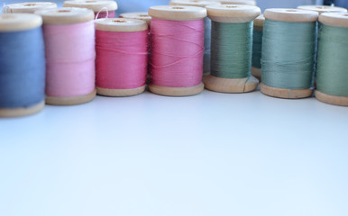 Colored reels of thread on white background, place for text