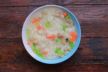 Thai rice soup with pork breakfast food on wooden background 