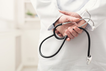 Male hand holding stethoscope closeup