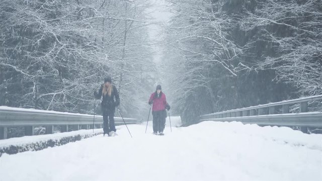 Wide shot of three young ladies hiking on a snowy day